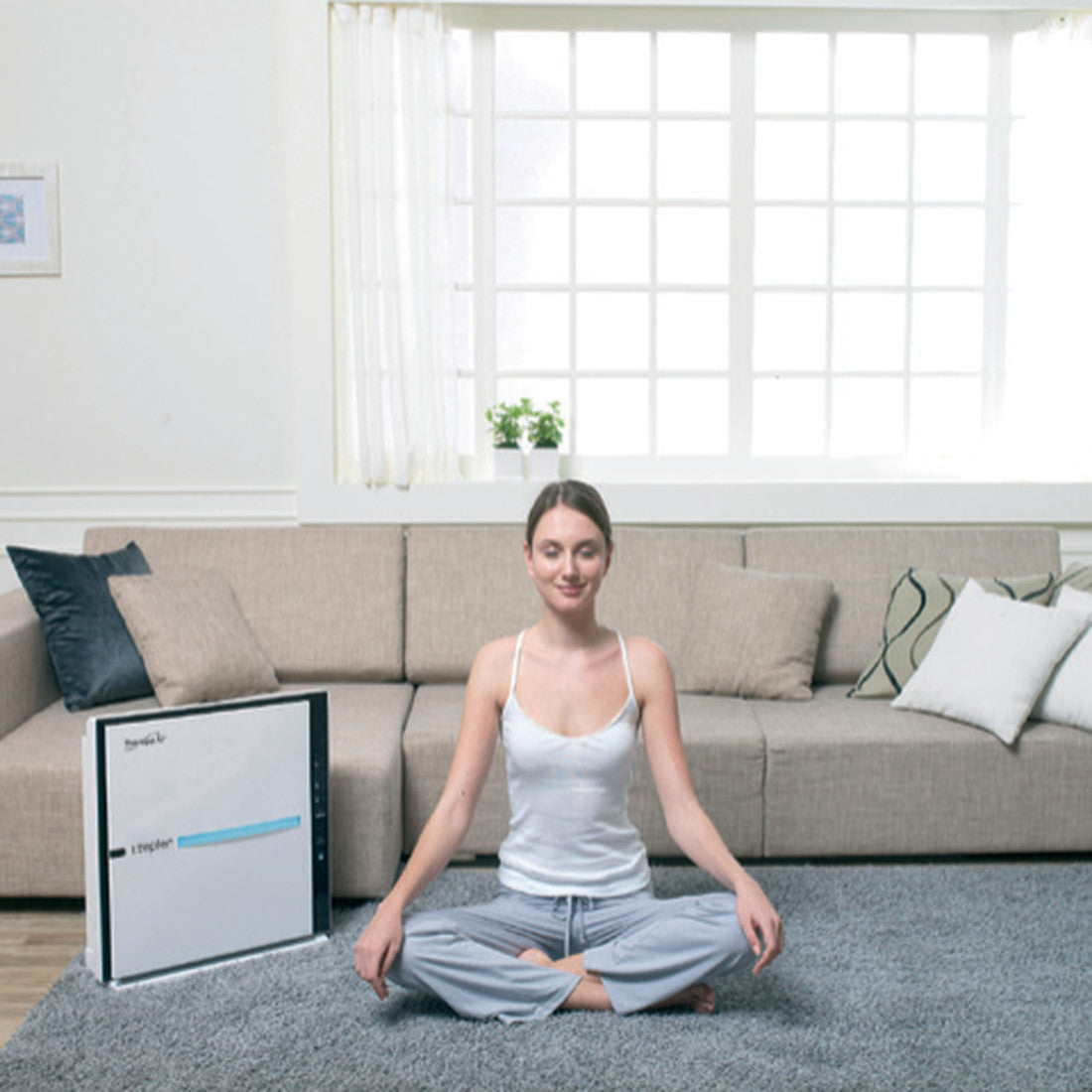 Žena vežba u sobi sa uključenim TherapyAir iOn prečišćivačem